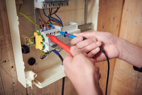 Twee handen van een student bezig met stroominstallatie