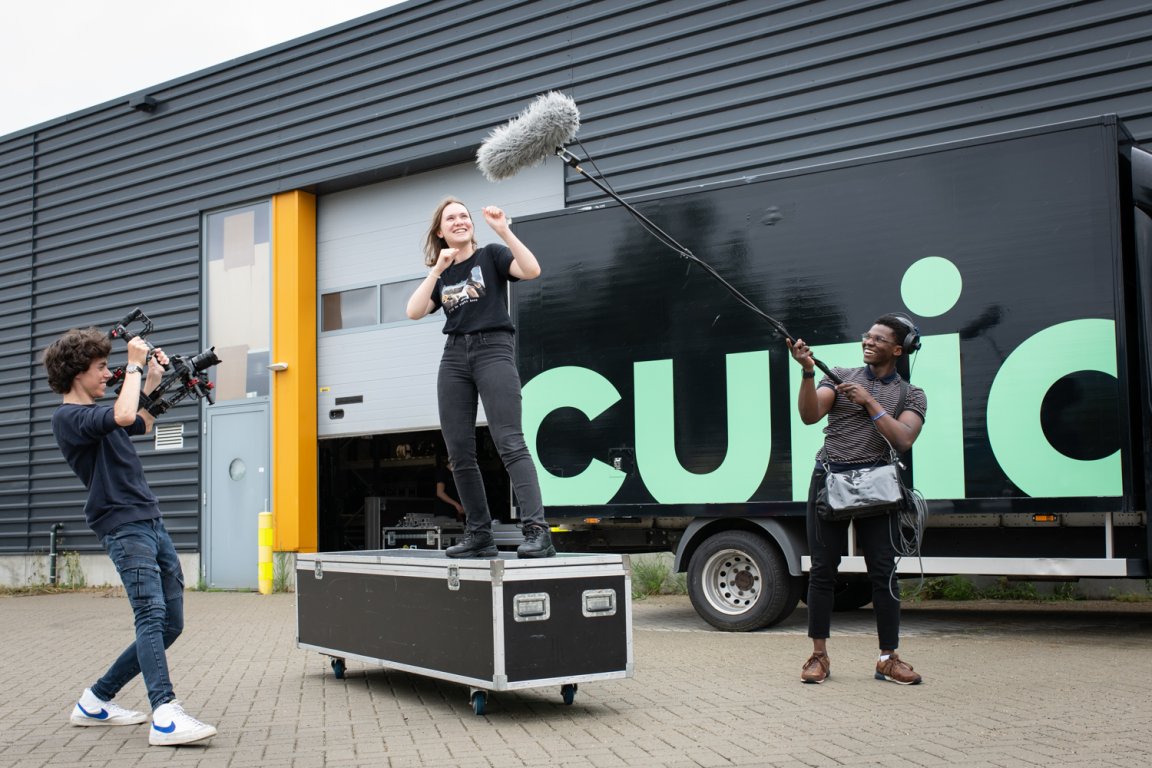 Studenten AV-specialist bezig met een opname buiten voor het schoolpand