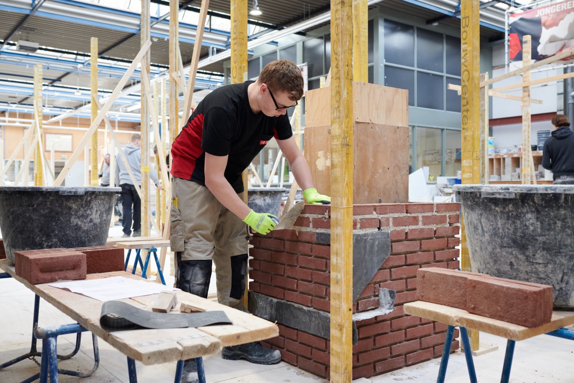 Student bezig met het metselen van een muurtje