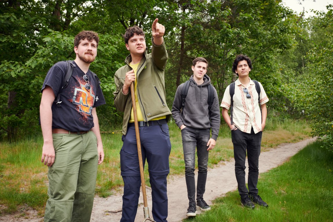 Docent wijst studenten iets aan in natuurlijke omgeving