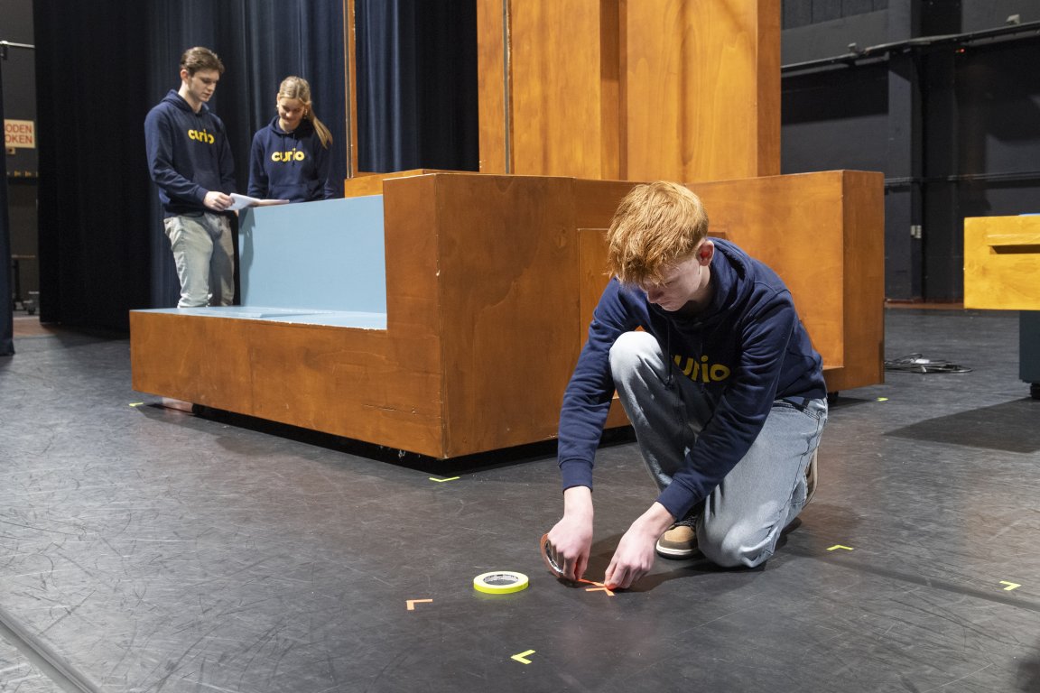Student bezig met tape plakken op de grond