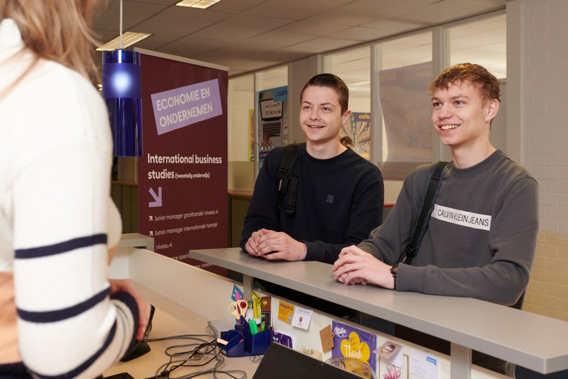 Twee studenten internationale handel in gesprek met een medestudent 