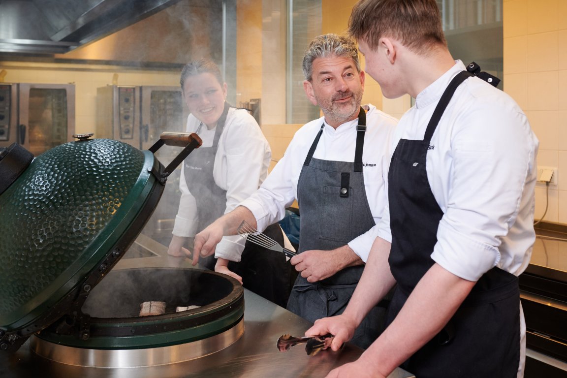 Twee studenten van de koks-opleiding krijgen uitleg van docent bij een green egg