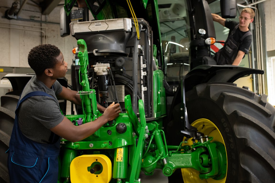 Twee studenten bezig met de reparatie van een tractor