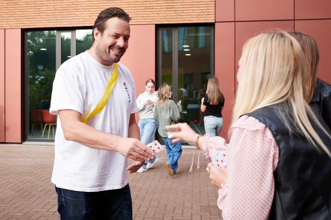 Docent wisselt een kaart uit een kaartspel met een student