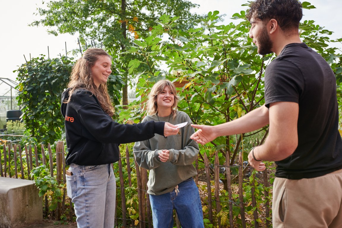 Student geeft een kaartje aan een medestudent