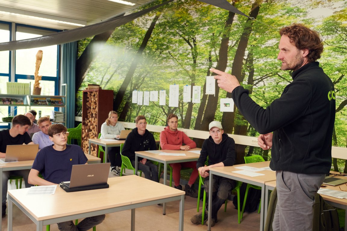 Docent legt zijn studenten iets uit in de klas