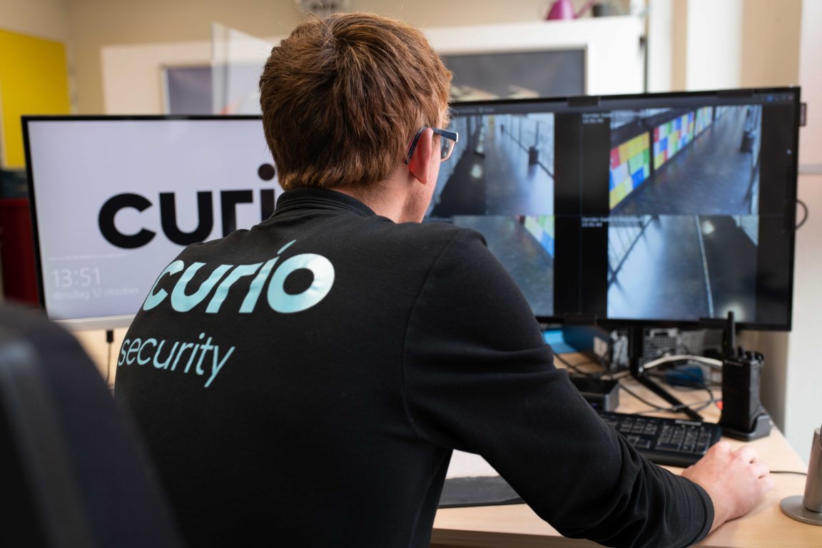 Student beveiliging kijkend naar een scherm met camerabeelden 