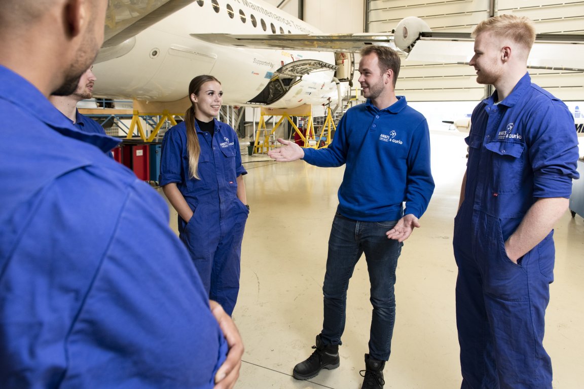 Studenten bij een vliegtuig.