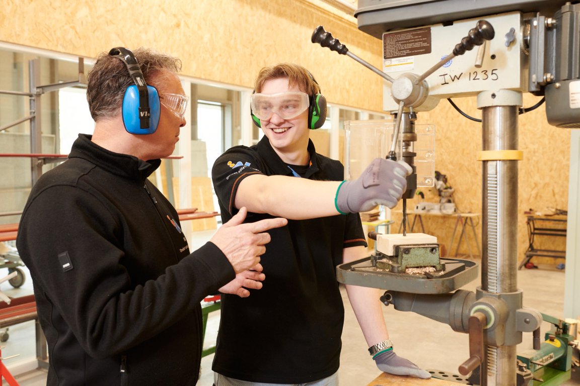 docent helpt bij machine